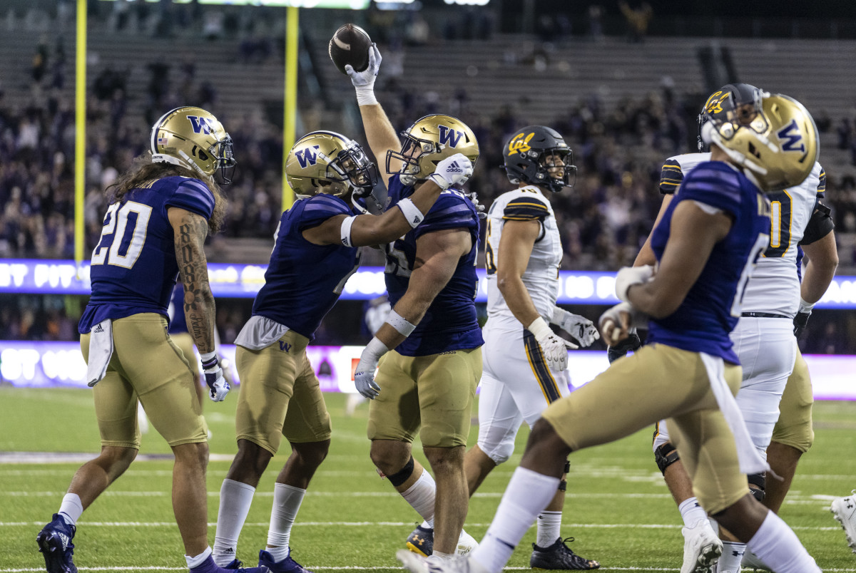 Washington Huskies defensive back Asa Turner (20), defensive back Kyler Gordon (2), second from left, celebrate after linebacker Ryan Bowman (55), center, recovered a California Golden Bears fumble.